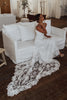 Bride sitting on white couch wearing the Rosa Ivory Gown